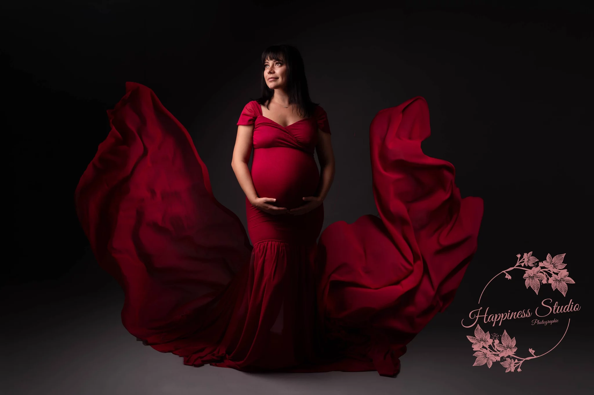Future maman en robe rouge avec voilage lors d’une séance photo grossesse à Lyon