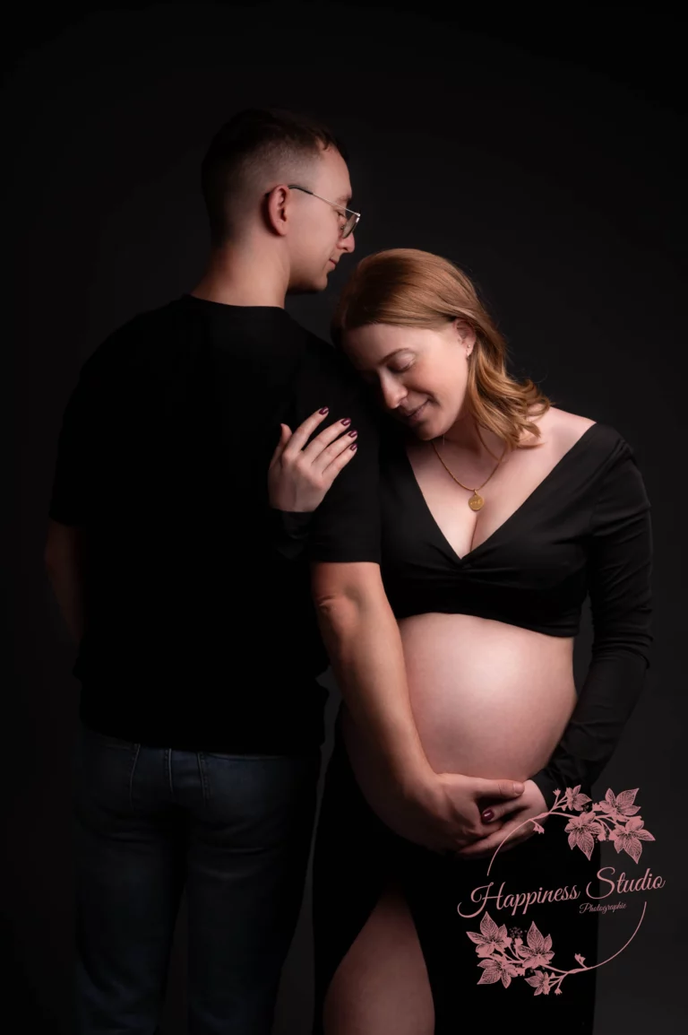 Moment de complicité entre futurs parents pendant une séance grossesse